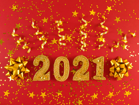 Greeting card of New Year 2021. Golden glittered figures, stars, bows and ribbons on red background.