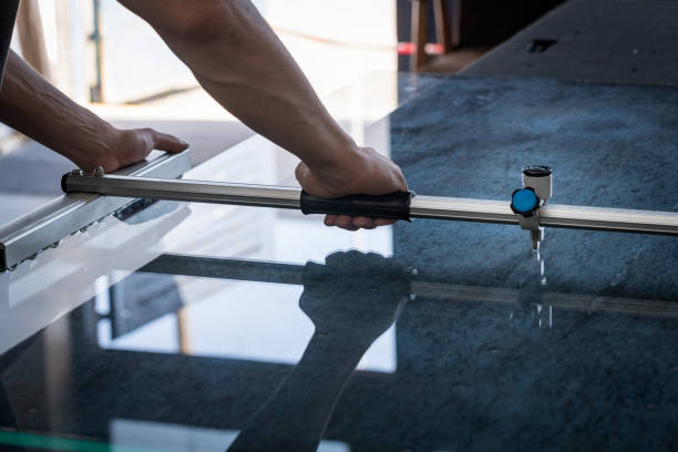 ein mann schneidet das glas mit hilfe von spezialwerkzeugen in einer glaswerkstatt - hand tool glass metal condition stock-fotos und bilder
