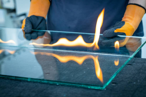 Hand lighting tea light candle in glass holder in the dark