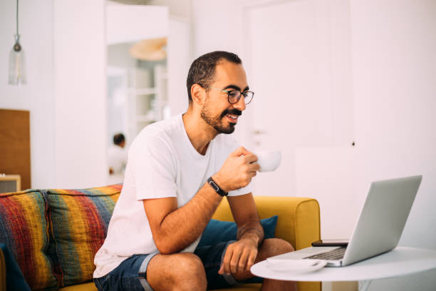istock Man using laptop in living room 1279391609