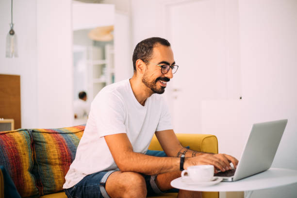 istock Man using laptop in living room 1279391741