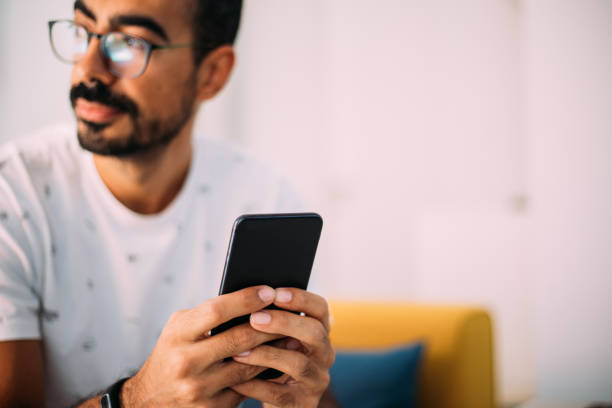 istock Man using smartphone in living room 1279391820