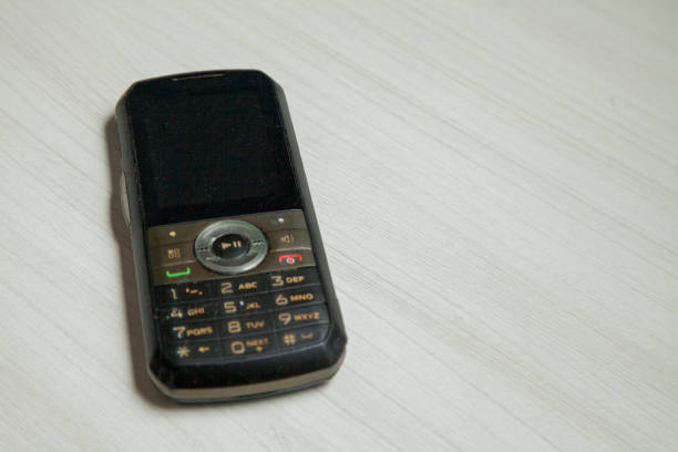istock Old cellular device placed on the table top in the home office, showing the screen, keyboard and old electronic device technology. 1279391903