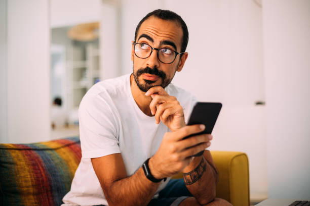 istock Man using smartphone in living room 1279391916