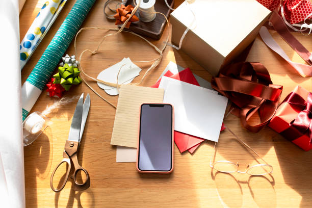 istock Packing Christmas Presents: a Messy Tabletop Composition of Various Decorative Items: Wrapping Paper, Ribbons, Gift Boxes, Christmas Cards 1279395369
