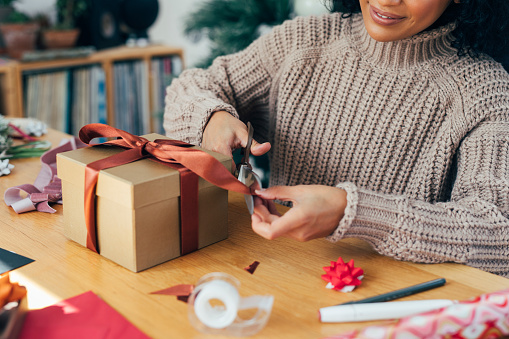 Getting Ready for Christmas: a Happy Young Woman Packing Christmas Presents for her Loved Ones, a Close Up