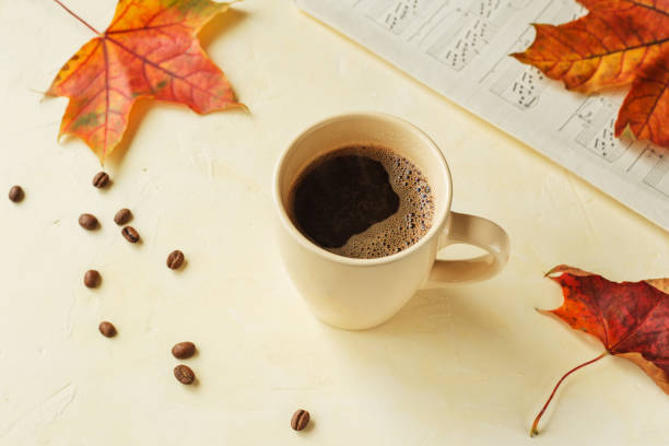 istock Autumn background with a cup of hot aromatic coffee on light concrete table surrounded by autumn leaves, coffee beans and music notes. 1279397135