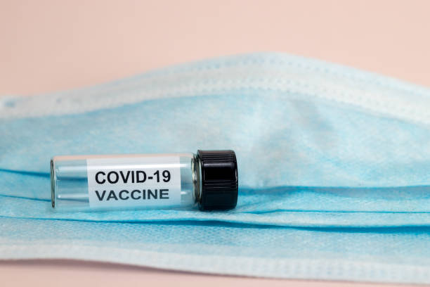 istock Coronavirus Covid-19 Vaccine Bottle with face mask 1279401274