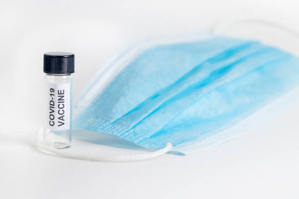 istock Coronavirus Covid-19 Vaccine Bottle with mask 1279401350