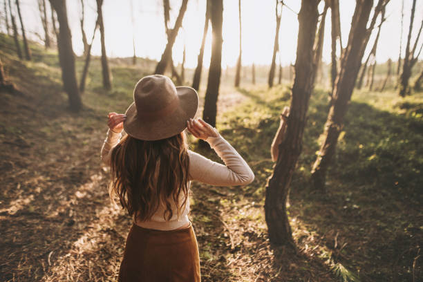istock Rear view of woman with hat at forest 1279402113