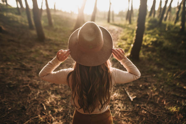 istock Rear view of woman with hat at forest 1279402863