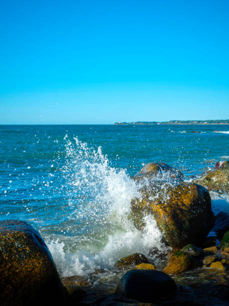 Seascape with sea rocks and splashing water in the autumn morning in the Vineyard Sound on Cape Cod, Massachusetts.