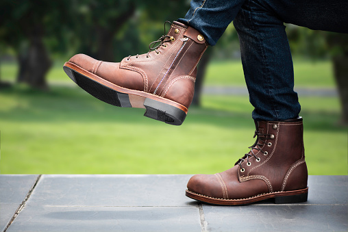 Men fashion in blue jeans and brown boots with zipper.