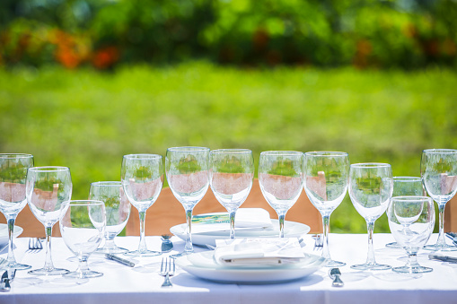 Outdoor dinner setting with wine glasses.