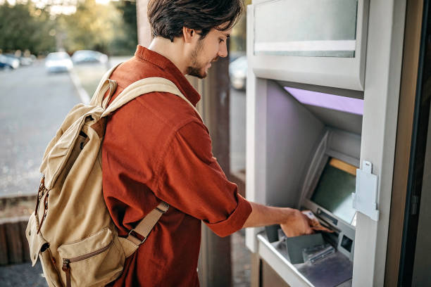 istock Men using ATM machine to withdraw money 1279418695