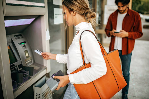 istock Young couple using ATM machine to withdraw money from credit card 1279420288