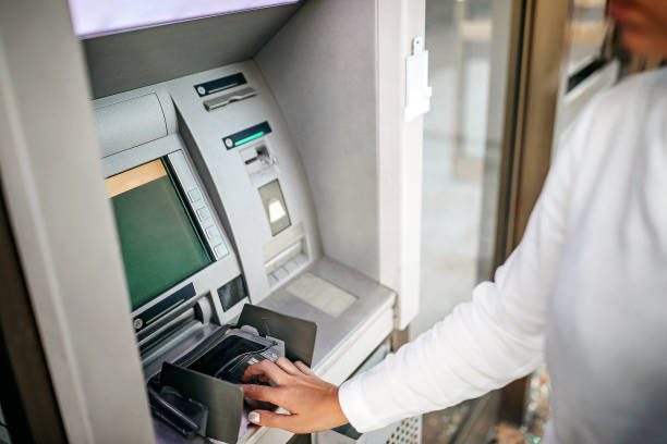 istock Women using ATM machine to withdraw money 1279420482