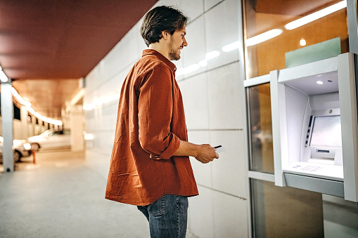 Men using ATM machine to withdraw money
