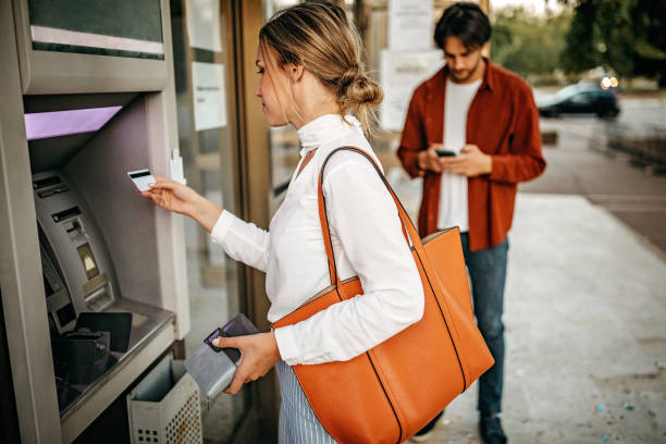 istock Young couple using ATM machine to withdraw money from credit card 1279422245