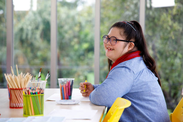 Asian girl with Down's syndrome studying in art class.