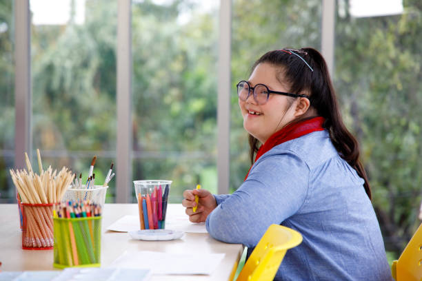 Asian girl with Down's syndrome studying in art class. Happy Asian girl with Down's syndrome studying in art class at school. Concept disabled child learning in school. crayon photos stock pictures, royalty-free photos & images
