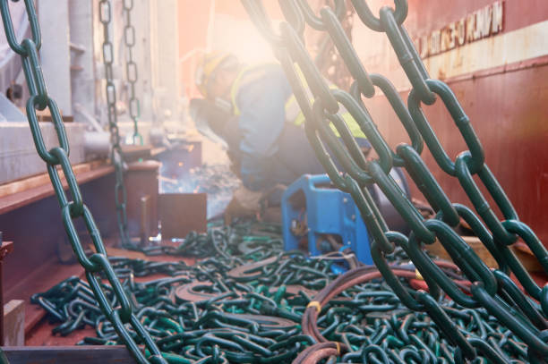 Welder doing welding on deck of ship lashing cargo