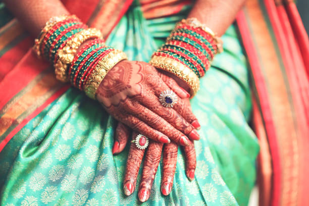 hermosas manos femeninas de una novia india con mehndi y joyas durante una boda típica hindú - sari fotografías e imágenes de stock