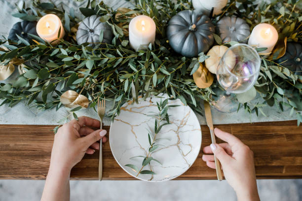 istock Female hands serving, on Autumn table setting with pumpkins. 1279434652