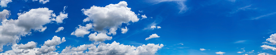 A panoramic skyscape with various clouds on a summer day.