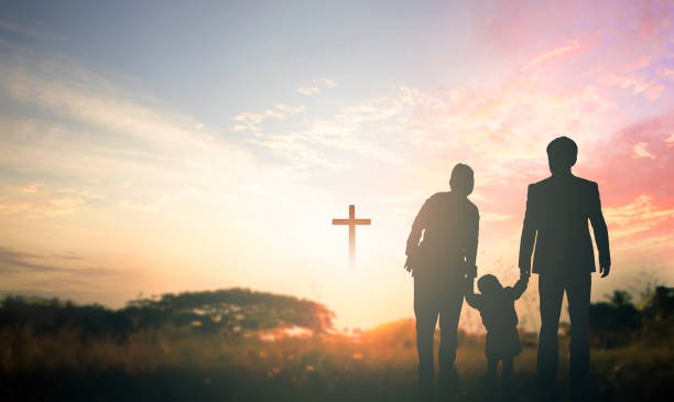 Family concept: Parents and children pray together on the cross background Family concept: Parents and children pray together on the cross background resurrection sunday stock pictures, royalty-free photos & images