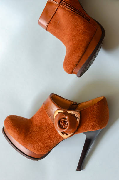 istock Brown women's ankle boots with high heels on a blue background. 1279441863