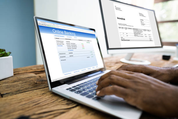 istock Young Businessman Looking At Invoice While Doing Online Banking 1279444312