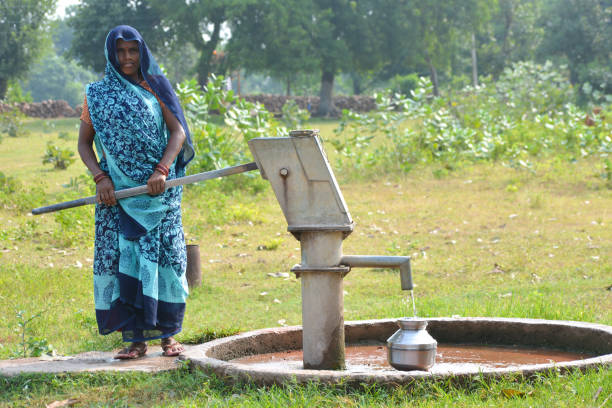 TIKAMGARH, MADHYA PRADESH, INDIA - SEPTEMBER 14, 2020: Unidentified Indian woman using hand pump for drinking water.