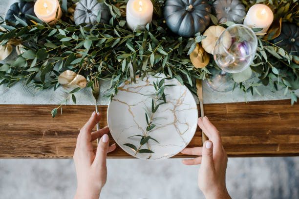 istock Female hands serving, on Autumn table setting with pumpkins. 1279450375