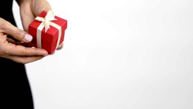 A women gets a present in red gift box with ribbon