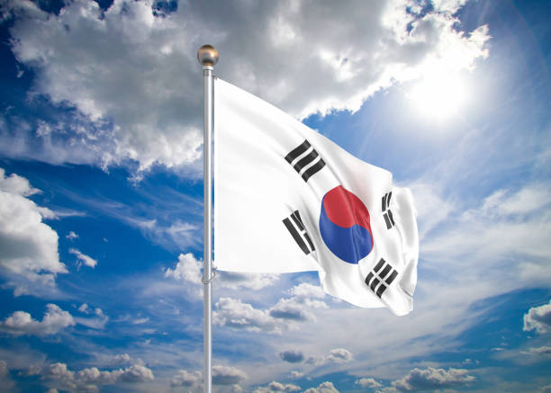 istock Realistic flag. 3D illustration. Colored waving flag of South Korea on sunny blue sky background. 1279458564