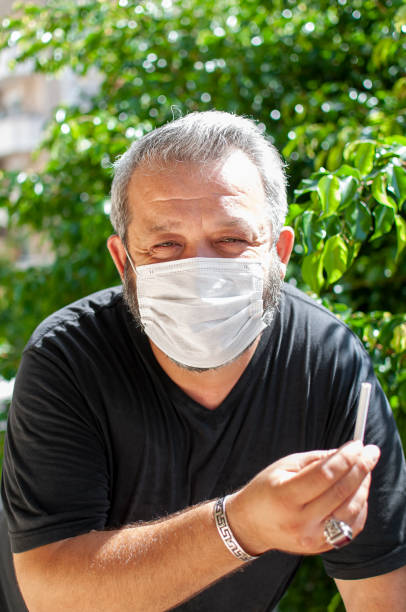 istock Man with protective face mask breaking cigarette after COVID-19 1279459648