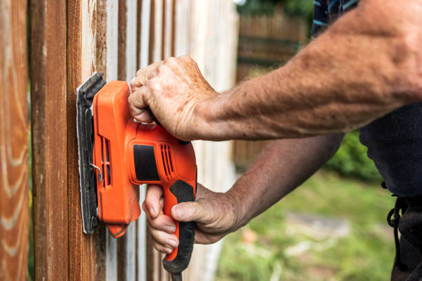 istock Man grinding picket fence by sander 1279459822