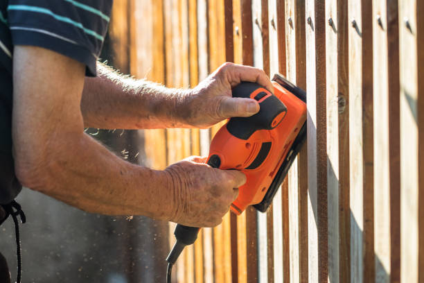 istock Man sanding wooden fence by sander 1279459868