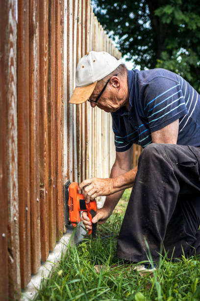 istock Old repairman sanding picket fence 1279460022