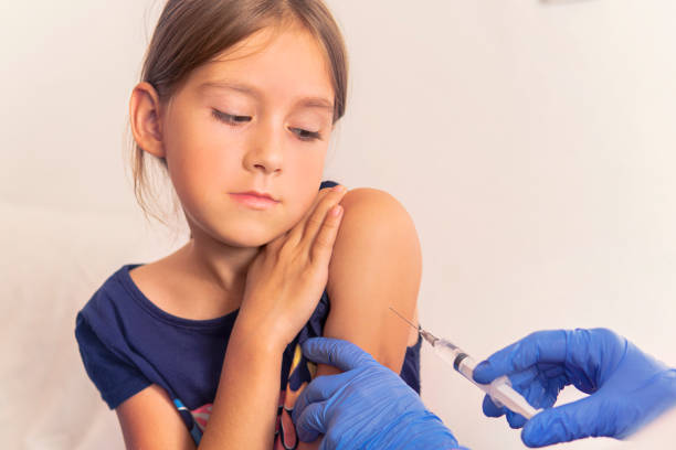 a little girl shows her shoulder to the doctor. shot of vaccination in the shoulder. a little girl shows her shoulder to the doctor. A shot of vaccination in the shoulder. human papilloma virus photos stock pictures, royalty-free photos & images