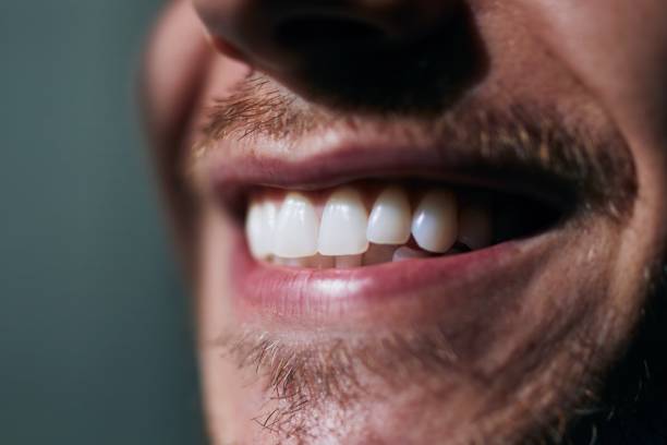 Toothy smile of young man Toothy smile of young man. Close-up view of white teeth. extreme close up stock pictures, royalty-free photos & images