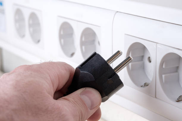 istock hand plugs the euro plug into the euro socket hanging on the wall 1279465059