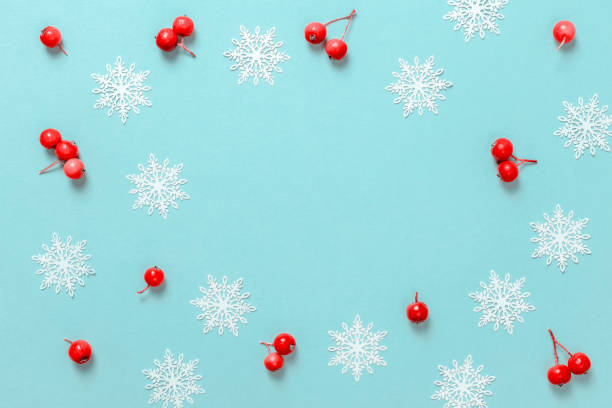 istock Xmas decoration. Red berry, white snowflakes in shape frame on pastel blue background for greeting card. Copy space. Winter holidays, New Year. 1279469834