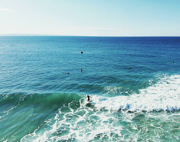istock Retro style surf scene as a surfer rides a wave in turquoise blue waters 1279470777