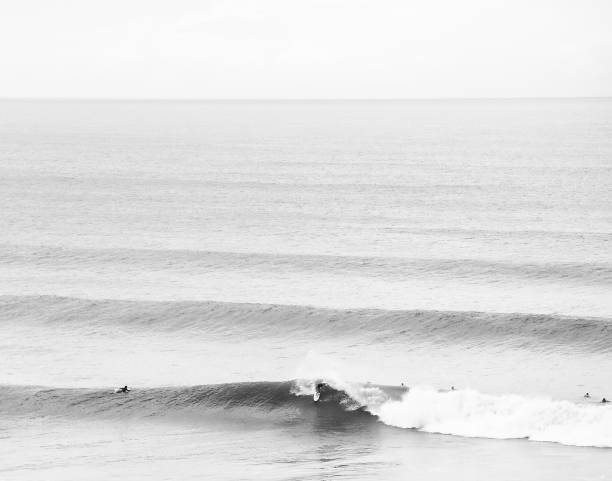 istock Black and white minimalistic surf background. A surfer does a big top turn in overhead waves 1279476072