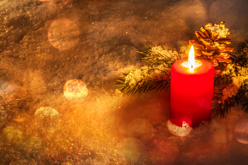 classical red christmas candlelight in the snow, warm lights in cozy atmosphere, xmas greeting card with copy space