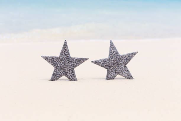 istock Stars decorations on sandy beach, greeting card 1279478916