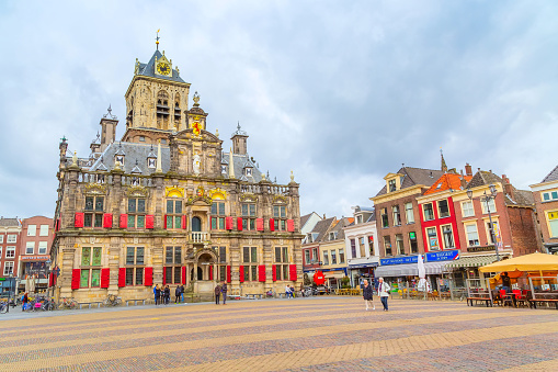 Delft, Netherlands - April 6, 2016: Stadhuis or City Hall, Markt square panorama with houses, people in Holland town