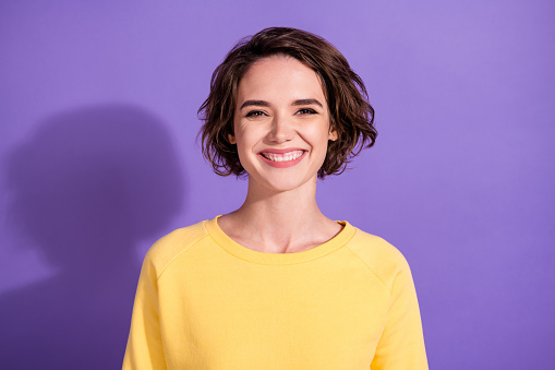Portrait of lovely girl look in camera toothy smile, wear bright sweatshirt isolated over violet color background